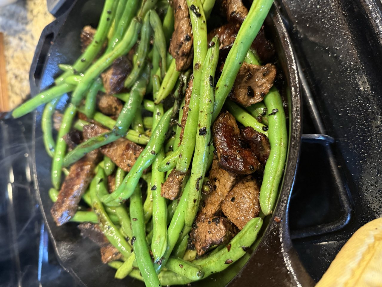 Seared beef and blistered green beans tossed together in the skillet